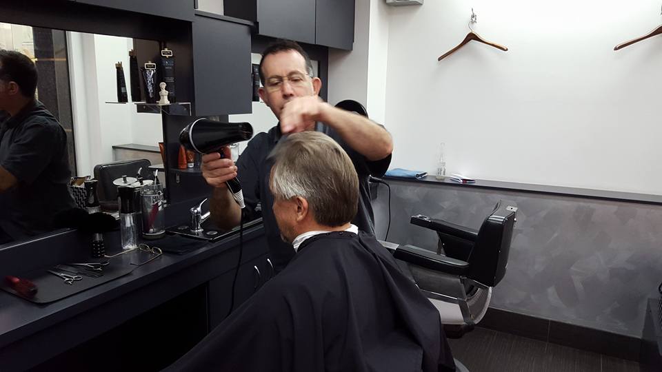 Owner Joe Micale busy putting finishing touches to another great hair syle for one of his regular customers.